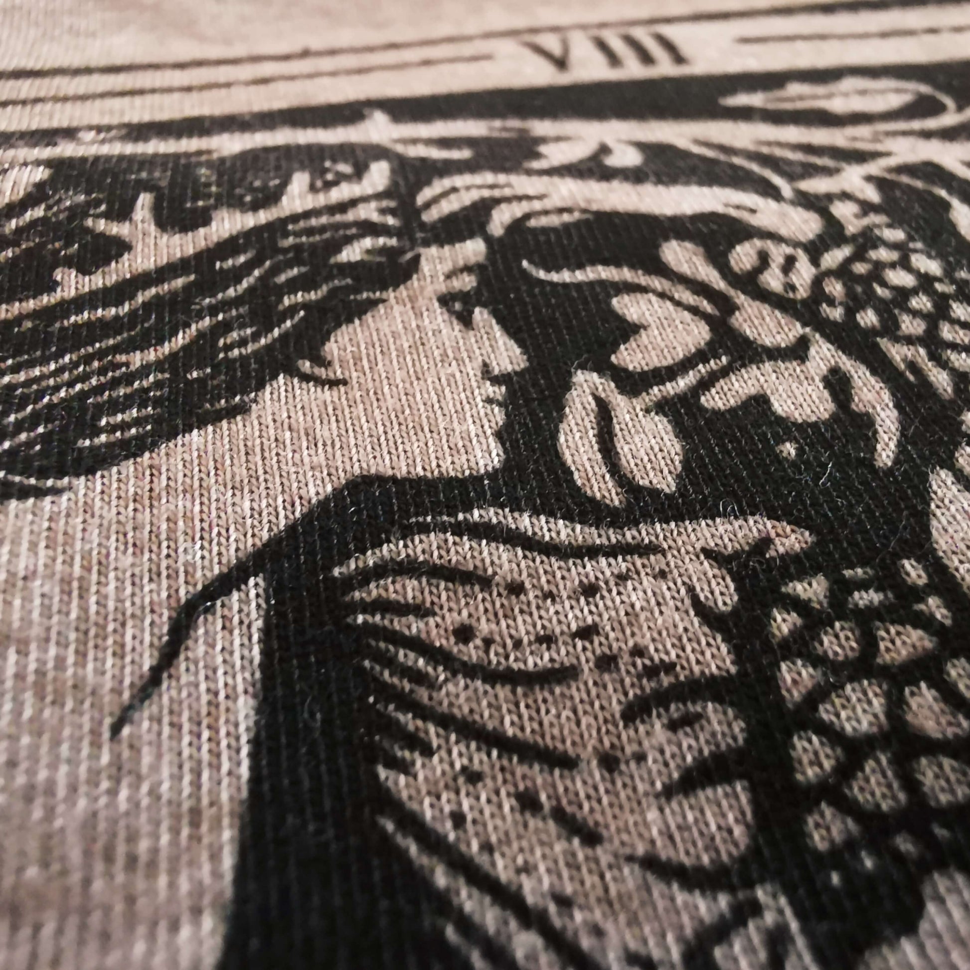 Close up to the quality screen print, where the print visibly has a very soft hand. 