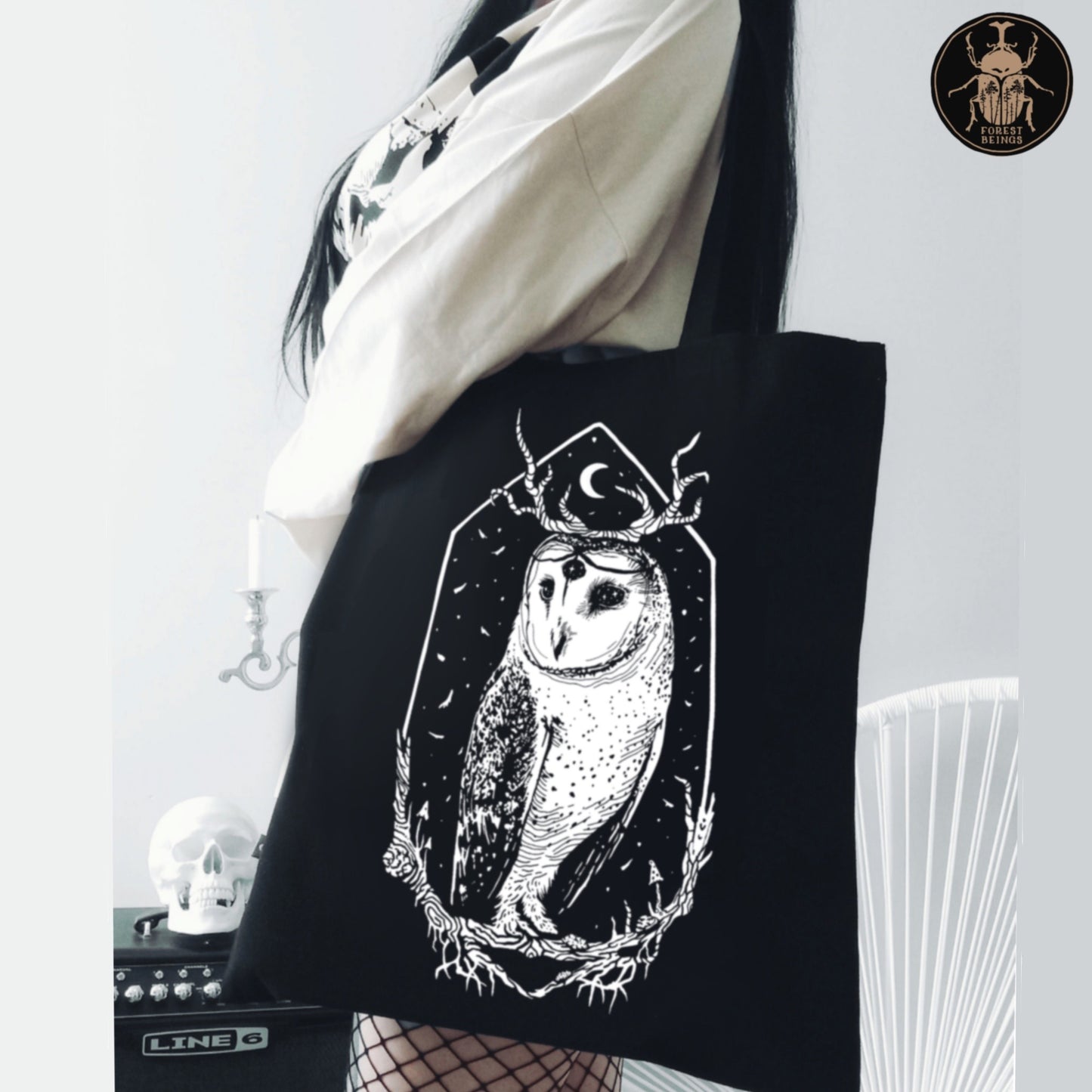 A gothic girl with fishnet stockings wearing a black gothic tote bag with a Stolas barn owl print on it.