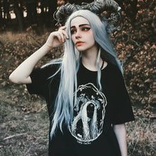 Load image into Gallery viewer, A forest witch with horns in the forest wearing a witchy gothic oversized t-shirt.
