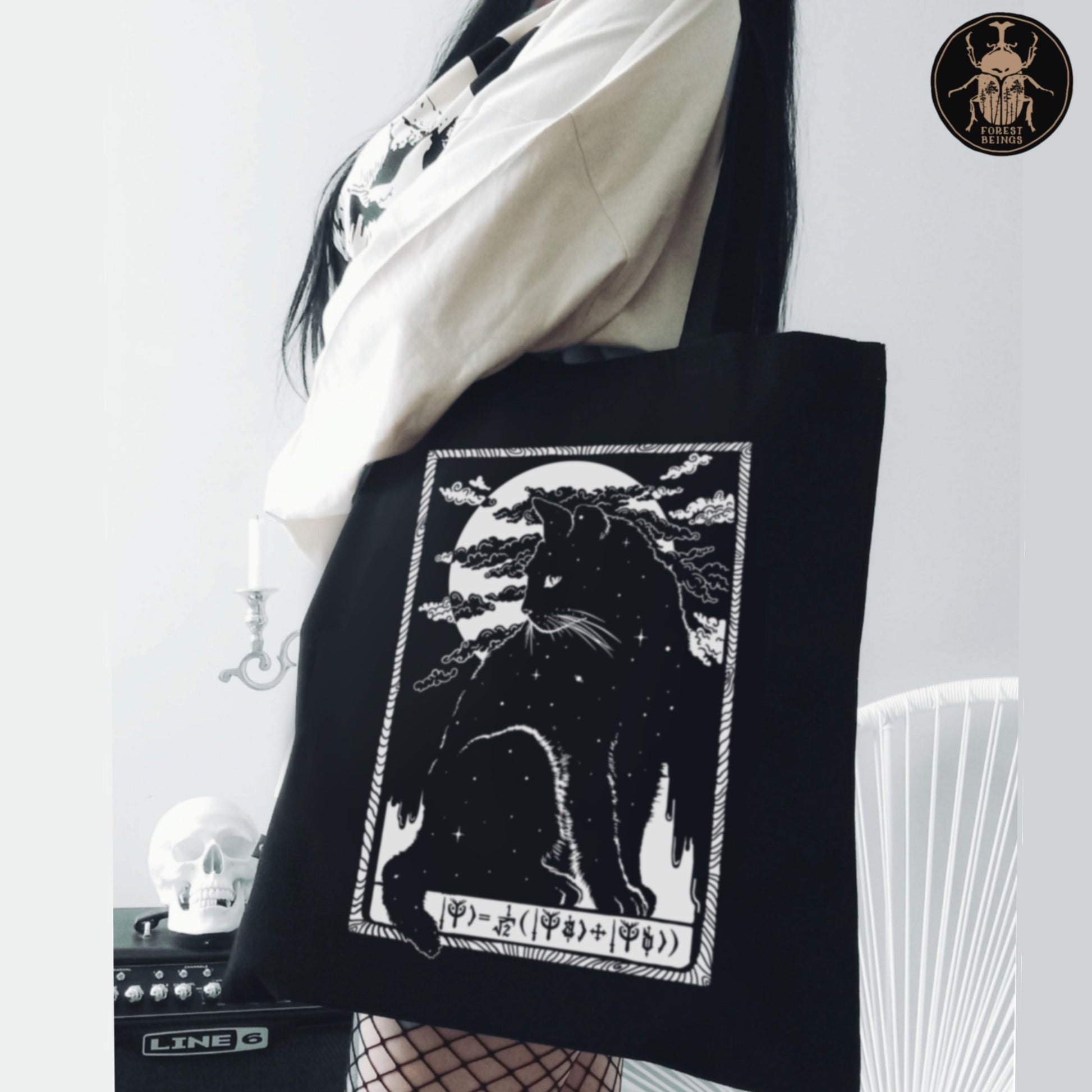 Schrodinger cat print on an aesthetic black tote bag worn by a gothic girl. 