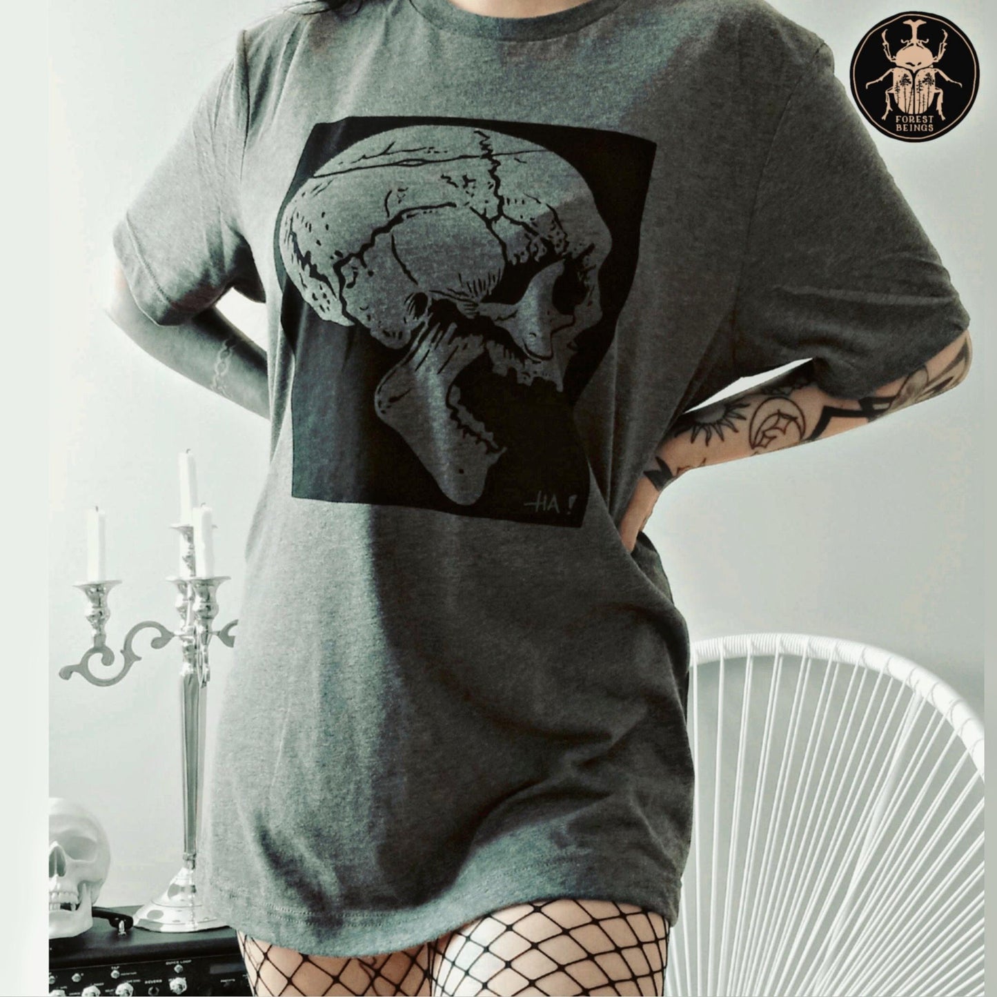 A sexy tattooed gothic girl wearing fishnet tights and an oversized grey gothic t-shirt. 