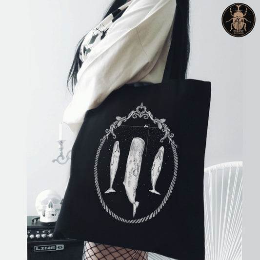 Sleeping sperm whales print on a black aesthetic gothic tote bag worn by a gothic girl. 