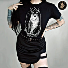 Load image into Gallery viewer,  Cute witchy goth girl with long black hair and tattoos on her arms and legs, wearing an aesthetic goth graphic t-shirt. The print on the t-shirt is the barn owl Stolas . 
