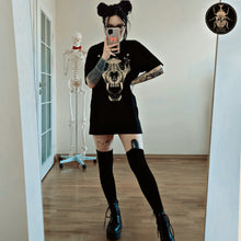 Load image into Gallery viewer,  Cute witchy goth girl with long black hair and tattoos on her arms and legs, wearing an aesthetic goth graphic t-shirt and a black stockings, a perfect gothic goblincore outfit.
