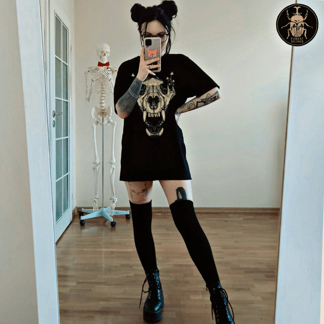  Cute witchy goth girl with long black hair and tattoos on her arms and legs, wearing an aesthetic goth graphic t-shirt and a black stockings, a perfect gothic goblincore outfit.